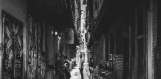Author alley grayscale photo of people in between of white concrete structures